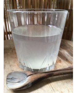 Verre d&#039;eau d&#039;argile, en verre avec une cuillère en bois
